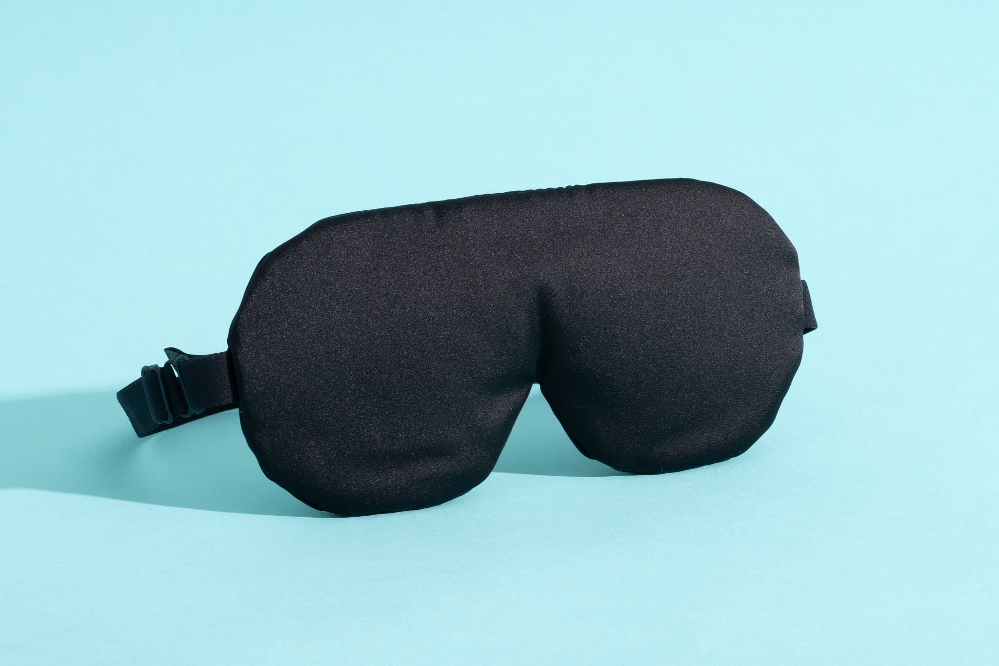 The Alaska Bear Natural Silk Sleep Mask on a blue background.